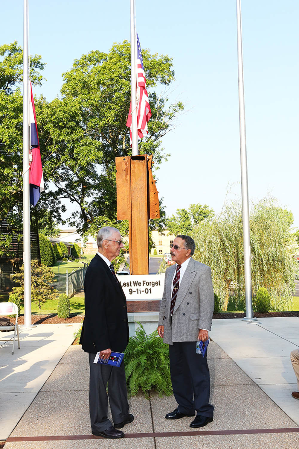 LEST WE FORGET
College of the Ozarks President Jerry Davis, left, visits with guest John Ligato at a Sept. 11 ceremony commemorating the lives lost in the terrorist attacks on the same date 18 years ago. The steel column behind them is a remnant of the World Trade Center and the focal point of the Lest We Forget 9/11 Memorial on the Point Lookout campus.